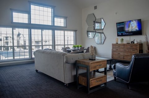 a living room with a couch and a tv and some windows